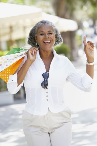 African woman carrying shopping bags and dancing