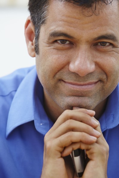 Close up of Hispanic businessman holding cell phone