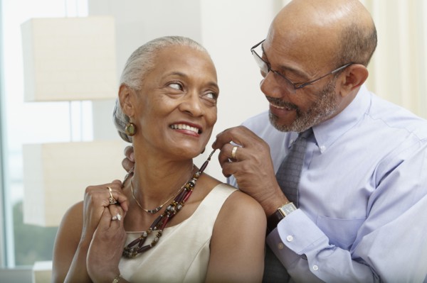 African man helping wife with necklace