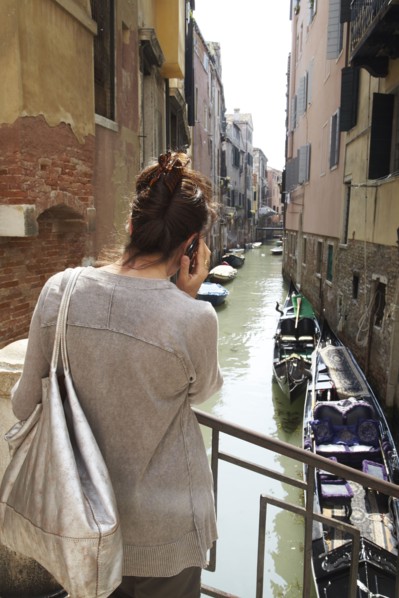 Italian woman talking on cell phone near canal