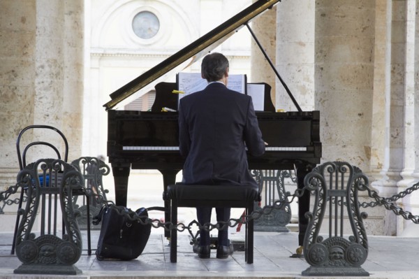 Pianist playing piano outdoors
