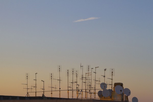 Silhouette of television antennas on rooftop