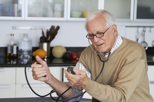 Caucasian man taking his own blood pressure