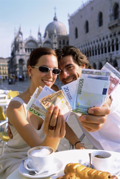 Couple with wads of cash having breakfast at cafe