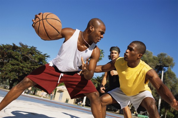 Men playing basketball outdoors