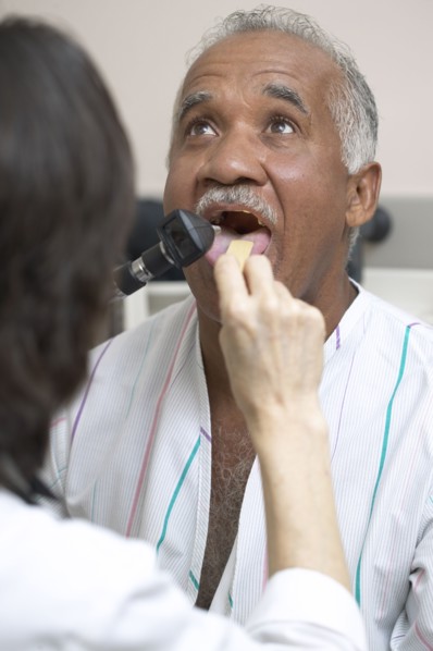 Doctor checking Senior man's tongue