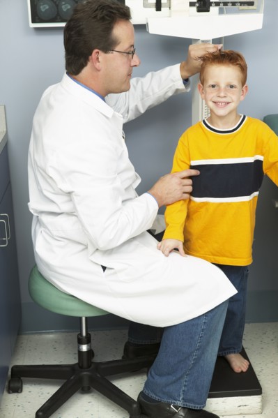 Doctor measuring boy's height in office