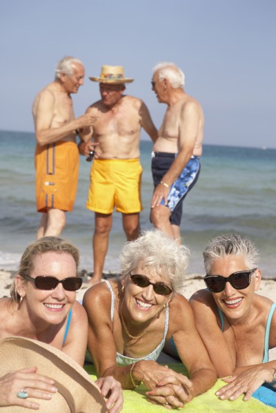 Senior friends relaxing on beach