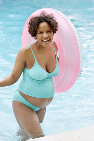 Pregnant woman cheering in swimming pool