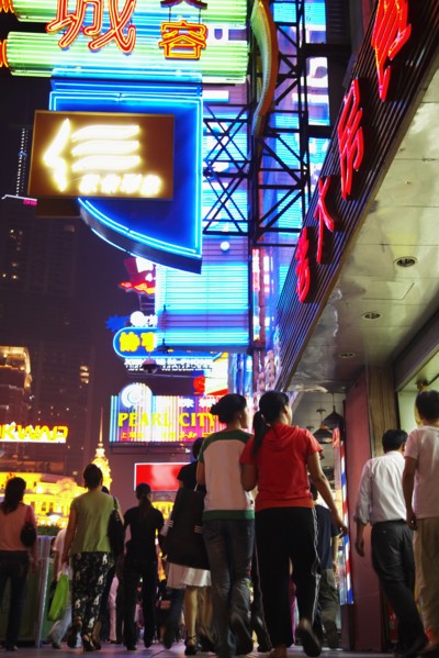 Couple on city street lit up at night