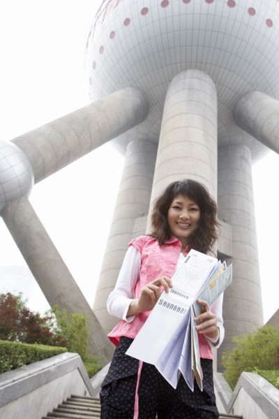 Chinese woman with map under Oriental Pearl Tower