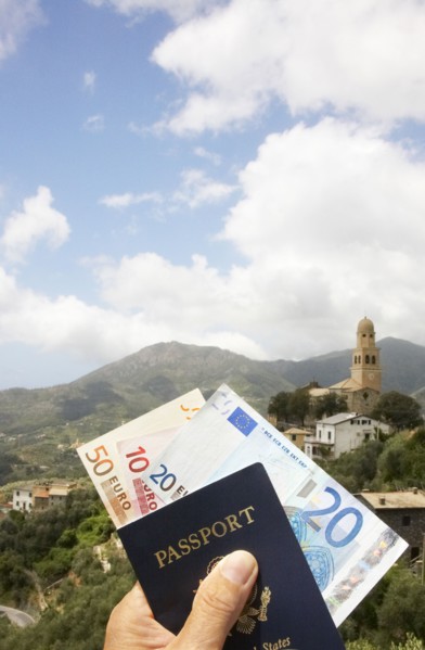Passport and Euros overlooking rural landscape