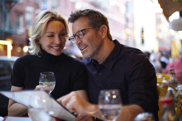 Caucasian couple reading menu at urban cafe