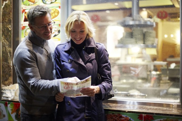 Caucasian couple reading menu at food cart