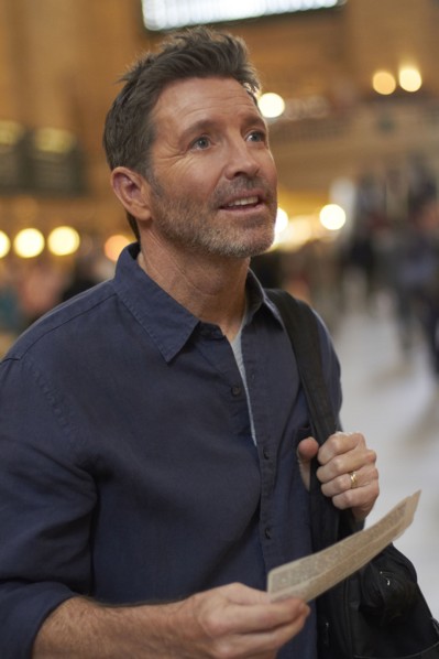 Caucasian man reading train schedule in Grand Central Station