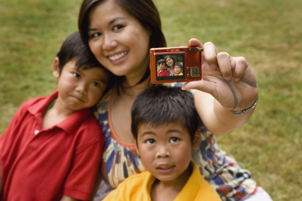 Asian mother and sons taking self-portrait