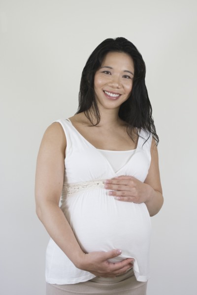 Pregnant Chinese woman holding stomach