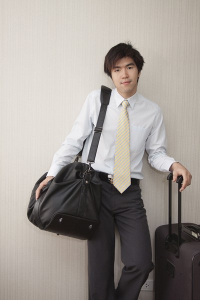 Chinese businessman standing with luggage