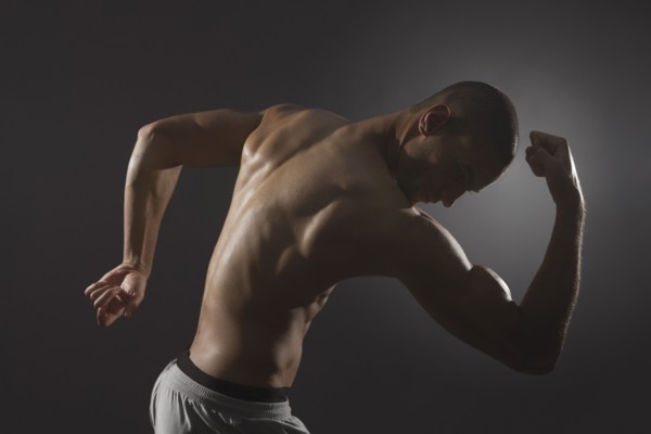 Mixed race athlete flexing biceps