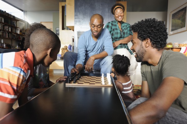 Black family watching chess game