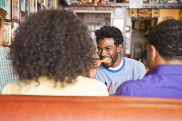 Smiling friends eating in diner booth