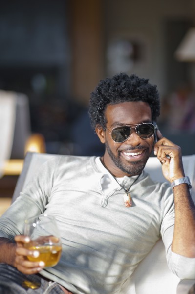 Black man talking on cell phone and drinking