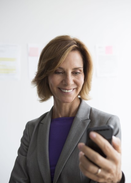 Caucasian businesswoman using cell phone in office