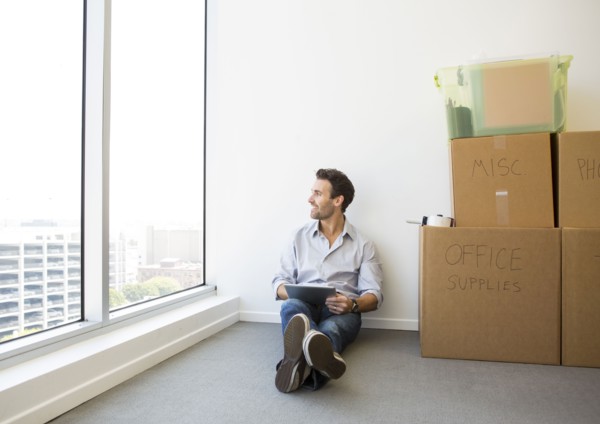 Hispanic businessman using digital tablet in new office