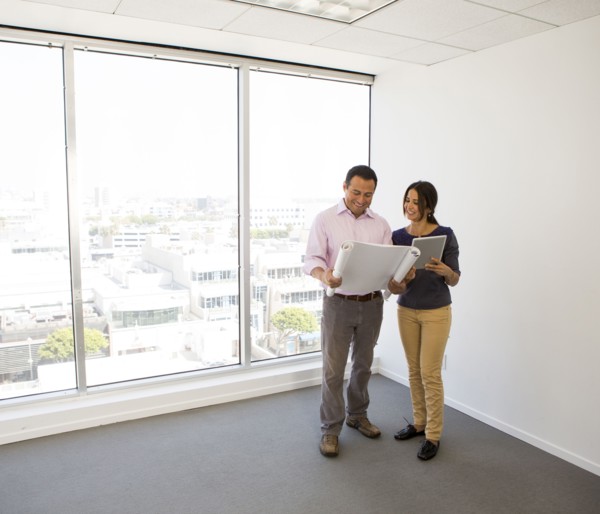Business people examining blueprints in office