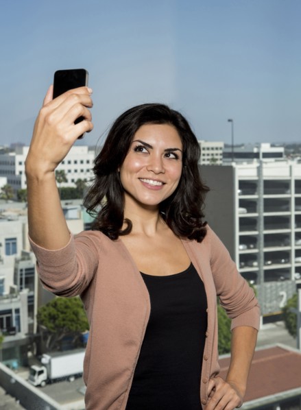 Mixed race businesswoman taking cell phone picture