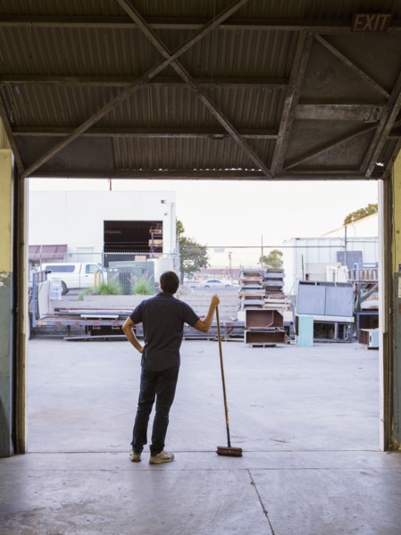 Worker holding broom in warehouse
