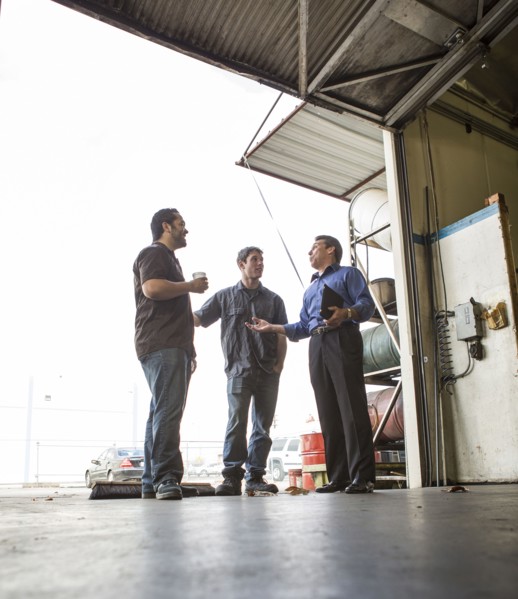 Manager and workers talking at warehouse loading dock