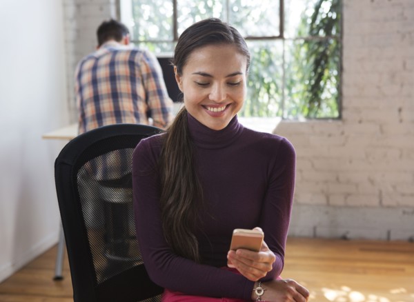 Mixed race architect using cell phone in office