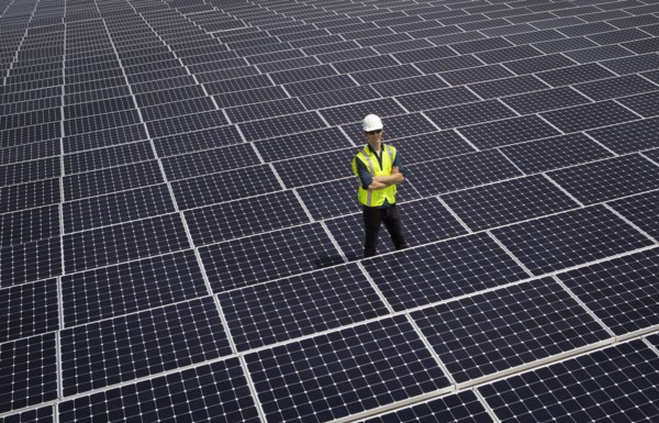 Caucasian technician smiling on solar panels
