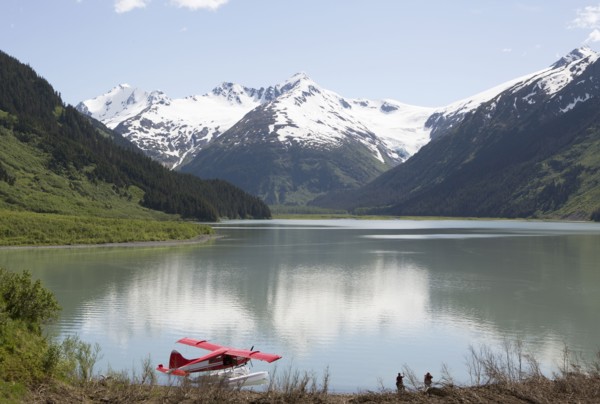 Seaplane docked in still lake in mountain landscape