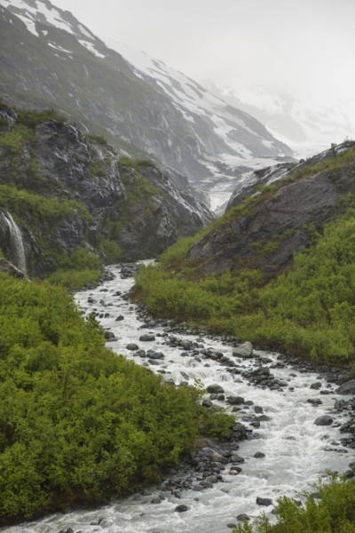 Rocky river flowing through snow covered mountains