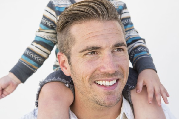 Close up of Caucasian father holding son on shoulders
