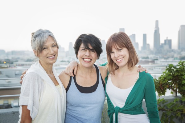 Women smiling together on urban rooftop