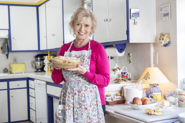 Older Caucasian woman baking pie in kitchen