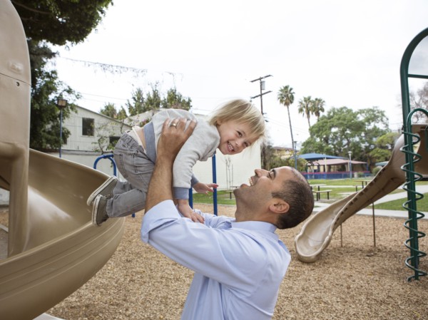 Hispanic father and son playing on playground