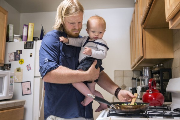 Caucasian father holding son and cooking