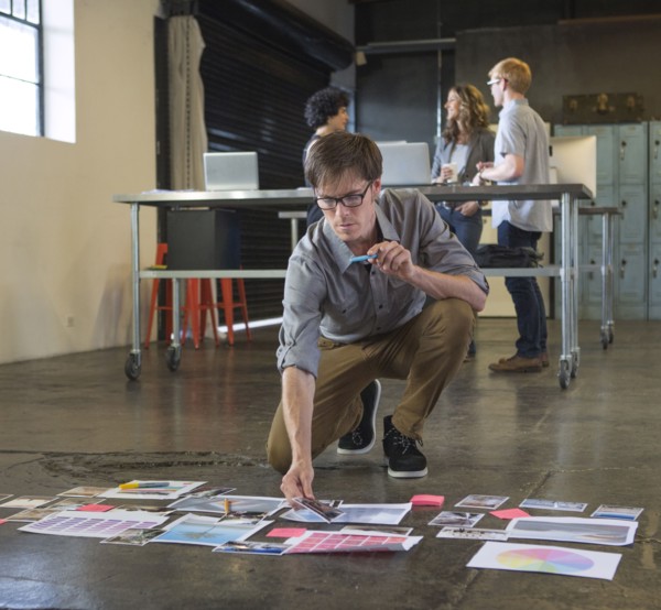 Caucasian businessman examining paperwork on office floor
