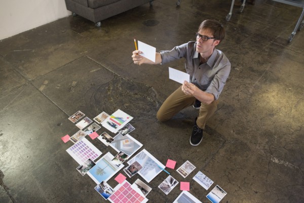 Caucasian businessman examining paperwork on office floor