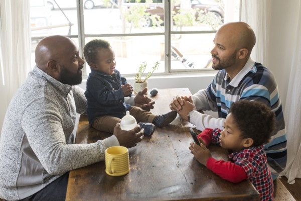 Fathers and children sitting at table