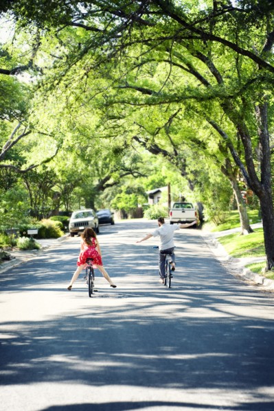 Caucasian children riding bicycles on suburban neighborhood street