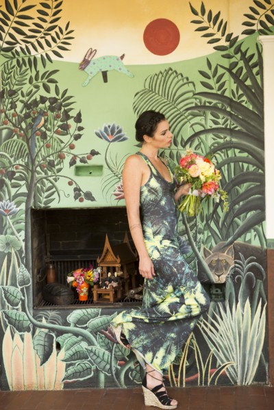 Woman wearing dress matching wallpaper