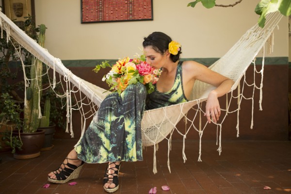 Woman smelling bouquet of flowers in hammock