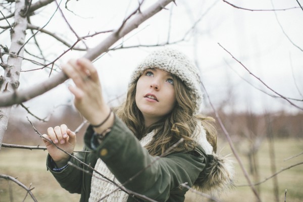 Caucasian woman examining tree branches