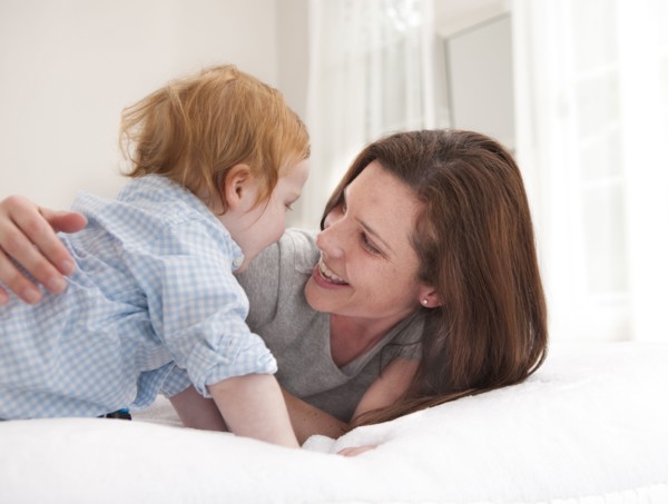 Mother and son playing on bed