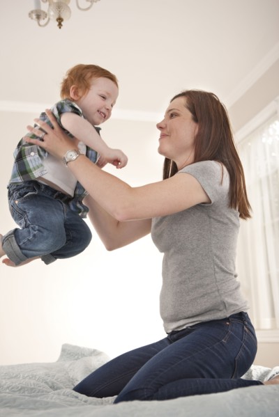 Mother and son playing on bed